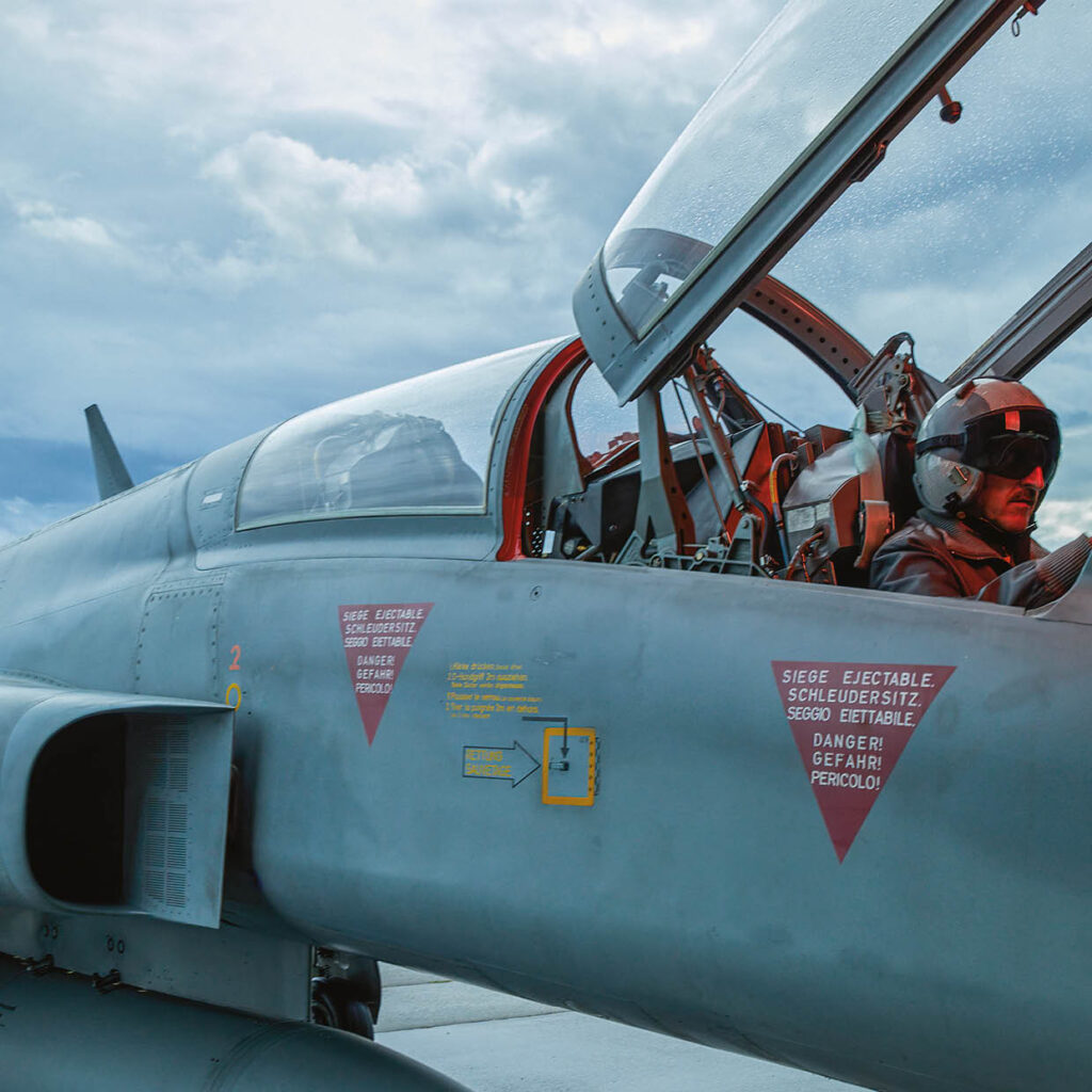 Military jet with open cockpit and a pilot inside